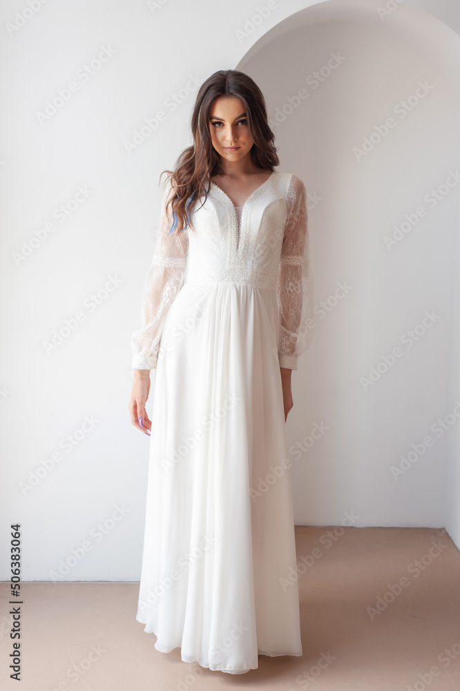 Beautiful woman wearing in luxurious long wedding dress. Concept of wedding hairstyle, makeup and accessories. Beautiful woman wearing in luxurious long wedding dress. Concept of wedding hairstyle, makeup and accessories.