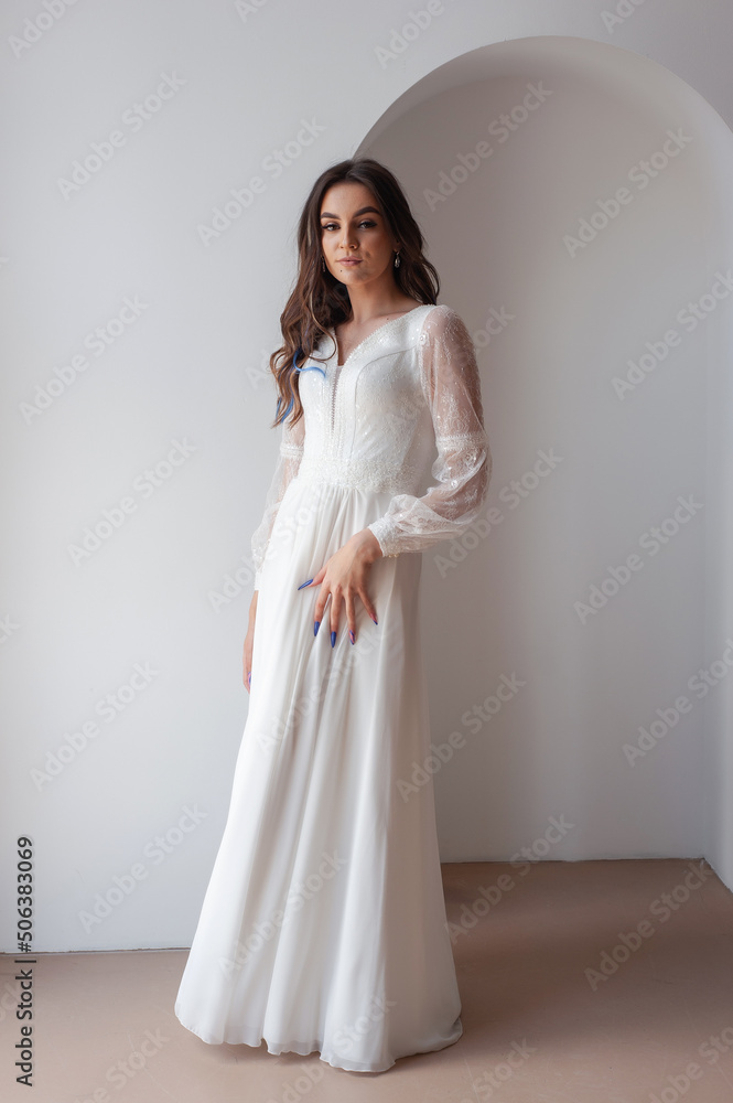 Beautiful woman wearing in luxurious long wedding dress. Concept of wedding hairstyle, makeup and accessories. Beautiful woman wearing in luxurious long wedding dress. Concept of wedding hairstyle, makeup and accessories.