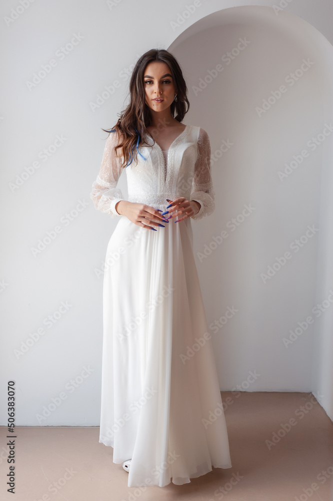 Beautiful woman wearing in luxurious long wedding dress. Concept of wedding hairstyle, makeup and accessories. Beautiful woman wearing in luxurious long wedding dress. Concept of wedding hairstyle, makeup and accessories.