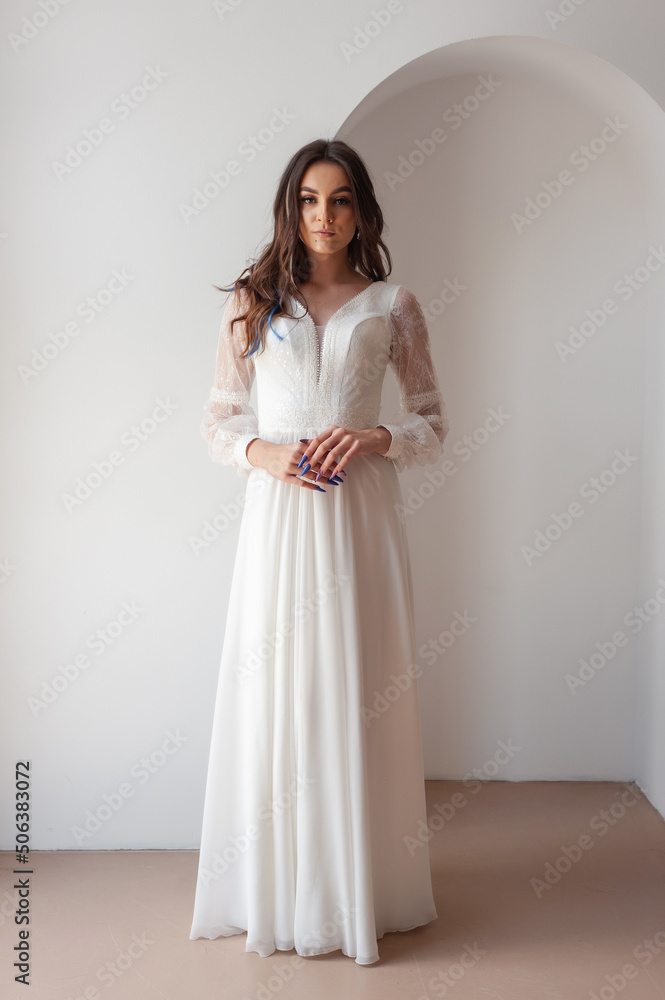 Beautiful woman wearing in luxurious long wedding dress. Concept of wedding hairstyle, makeup and accessories. Beautiful woman wearing in luxurious long wedding dress. Concept of wedding hairstyle, makeup and accessories.