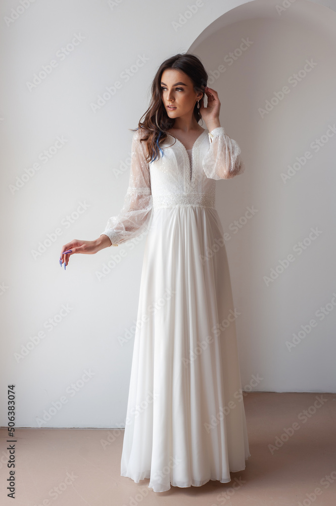 Beautiful woman wearing in luxurious long wedding dress. Concept of wedding hairstyle, makeup and accessories. Beautiful woman wearing in luxurious long wedding dress. Concept of wedding hairstyle, makeup and accessories.