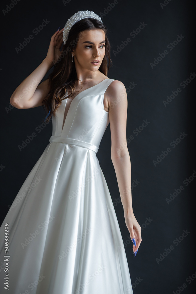 The beautiful woman posing in a wedding dress The beautiful woman posing in a wedding dress
