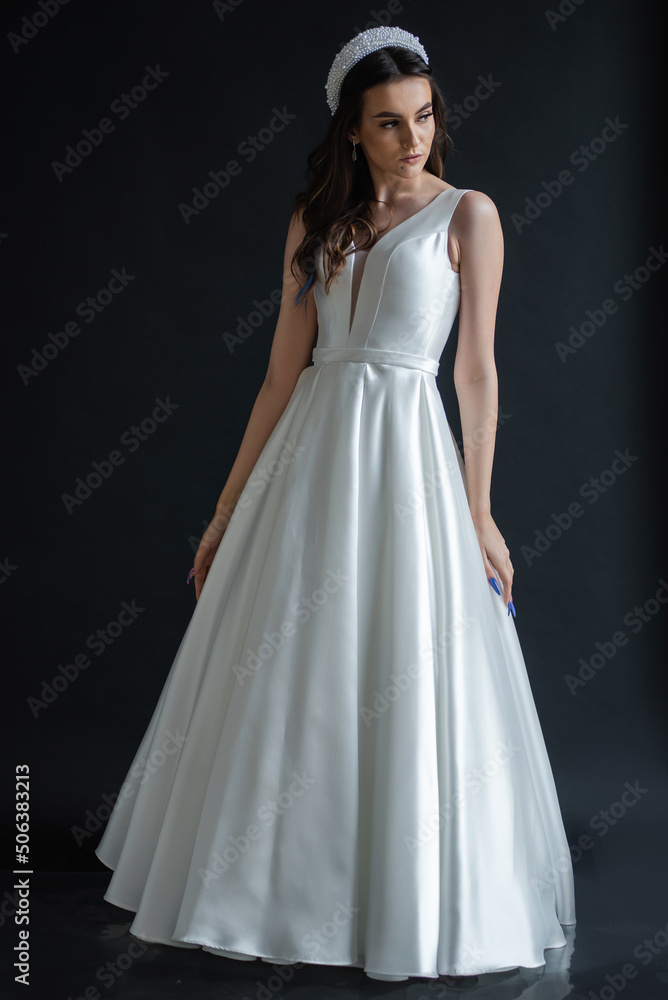 The beautiful woman posing in a wedding dress