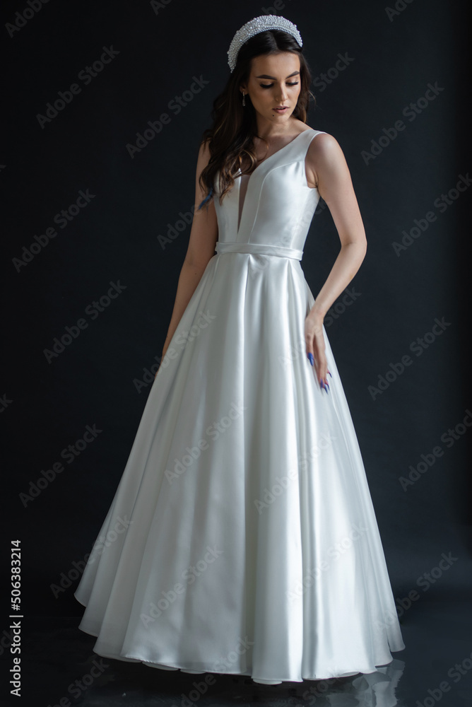 Beauty Portrait of bride wearing in wedding dress with voluminous skirt, studio photo. Young attractive bride. Smiling beautiful young bride