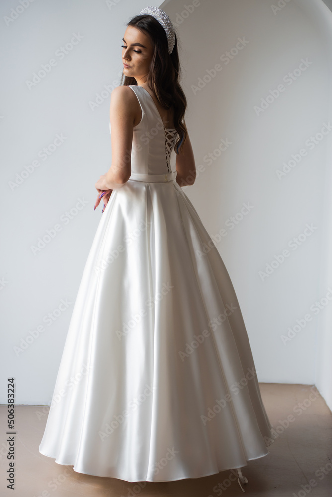 The beautiful woman posing in a wedding dress The beautiful woman posing in a wedding dress