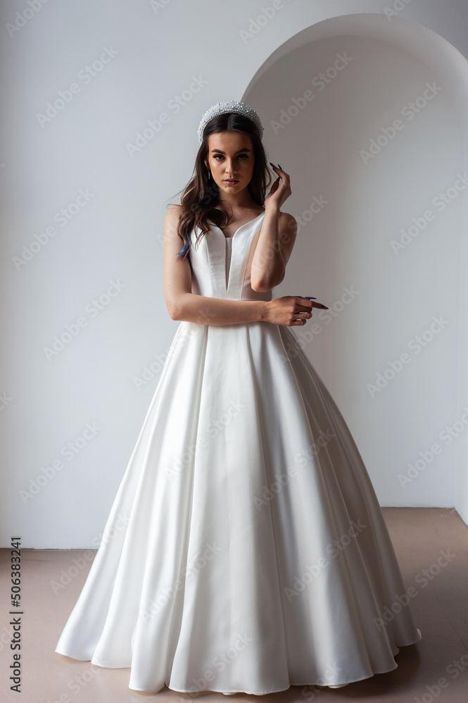 The beautiful woman posing in a wedding dress The beautiful woman posing in a wedding dress