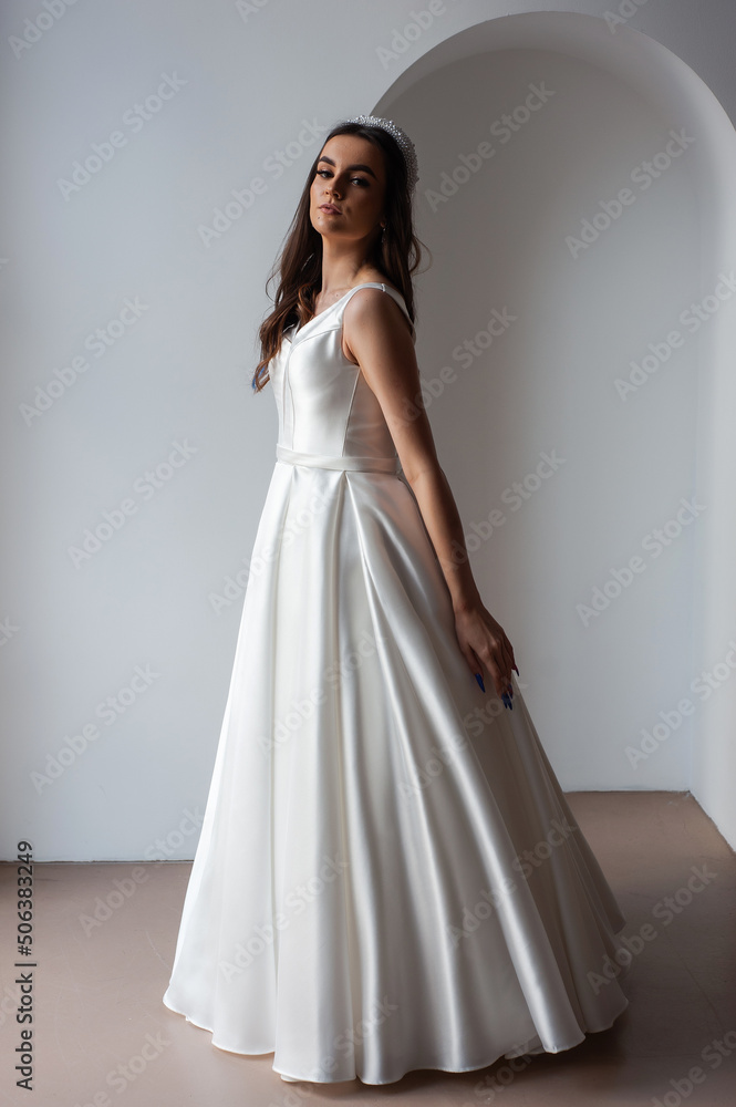 The beautiful woman posing in a wedding dress The beautiful woman posing in a wedding dress