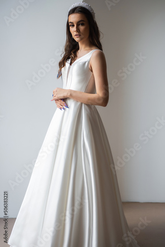 Beauty Portrait of bride wearing in wedding dress with voluminous skirt, studio photo. Young attractive bride. Smiling beautiful young bride
