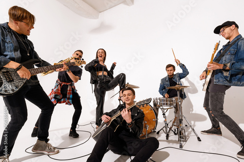 Εκτύπωση καμβά A young rock band of six people playing and singing on a white background