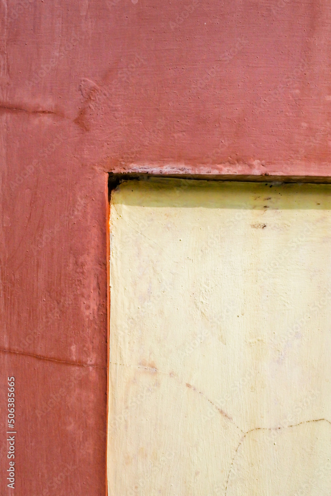 angled corner of the wall which is painted in two different colors, namely yellow and reddish brown