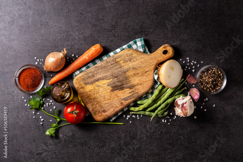 Assortment of vegetables, herbs and spices on black background. Top view. Copy space	