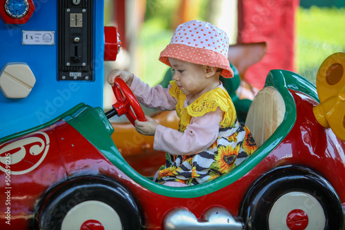 Bébé jouant dans une voiture de manège pour enfants photo