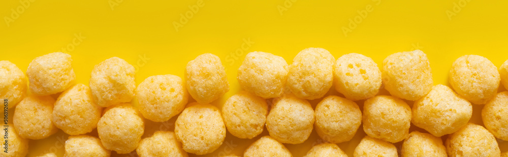 top view of puffed and tasty cheese pops on yellow, banner - obrazy, fototapety, plakaty 