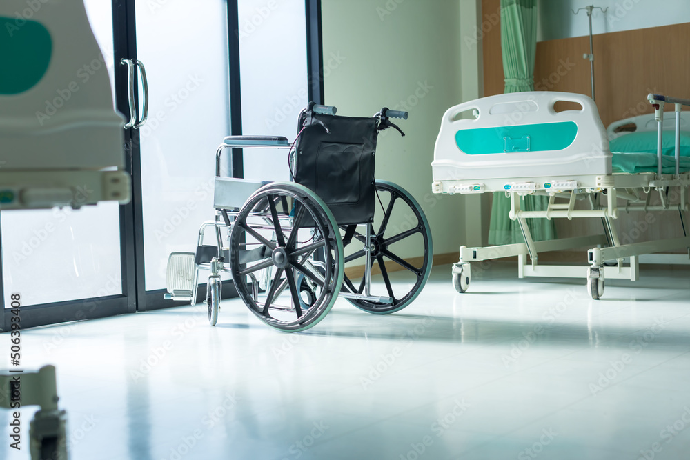 Empty wheelchair parked in Patient Rooms at hospital. The wheelchair patient is in the hospital ward. 