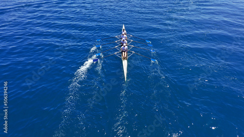 Aerial drone photo of sport canoe operated by team of young trained athletes in deep blue Aegean sea © aerial-drone