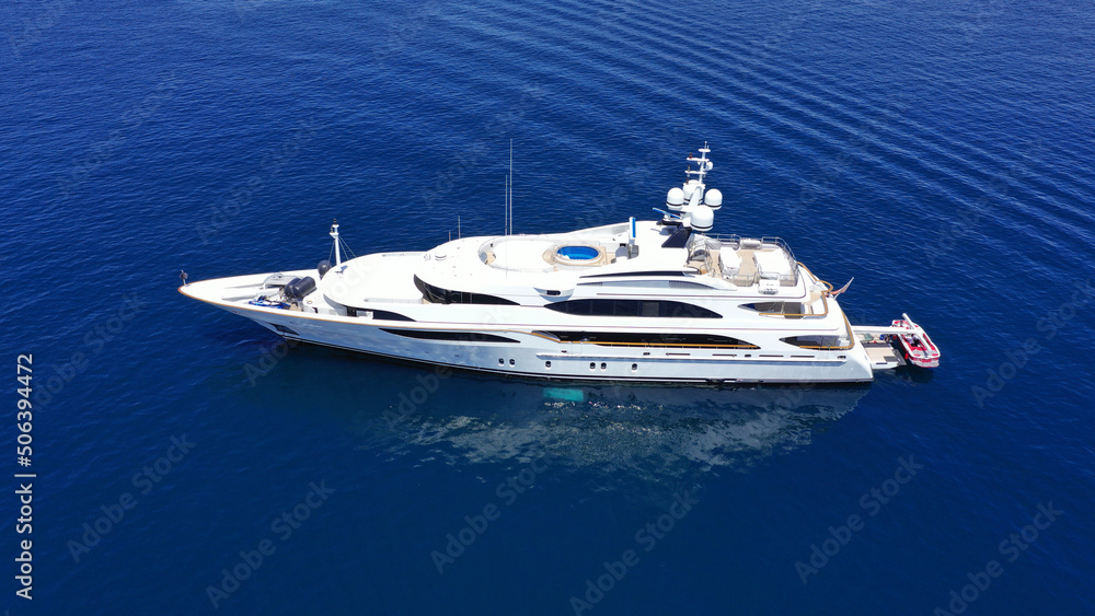 Naklejka premium Aerial drone photo of large yacht with wooden deck anchored in Aegean island deep blue sea