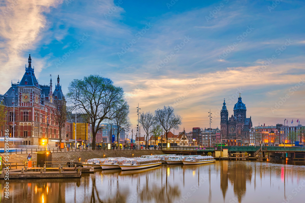 Amsterdam Netherlands, night city skyline at Amsterdam Central Station and Basilica of Saint Nicholas