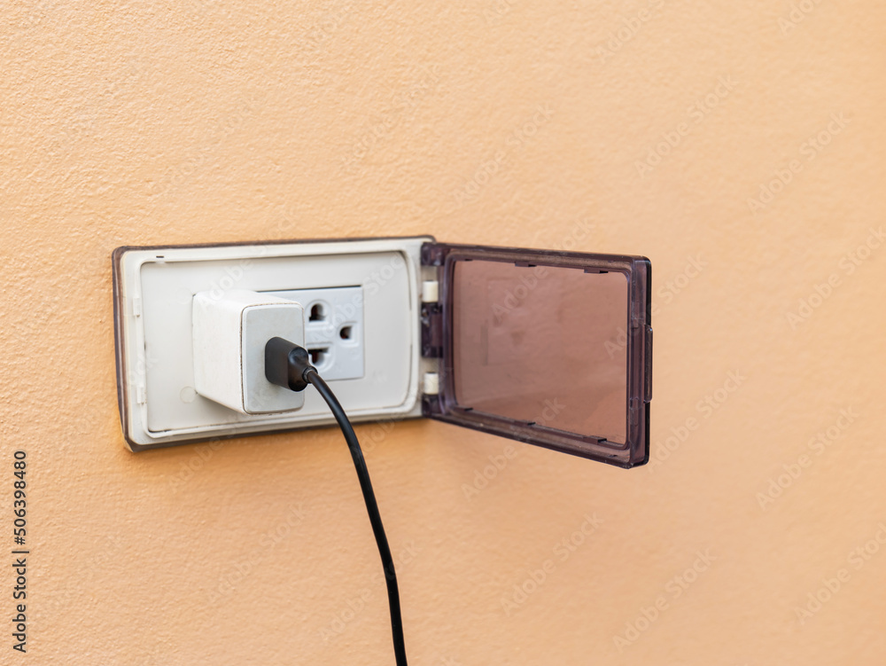 old white adapter There is a charging cable plugged in. With outdoor wall plugs, there is a cover that closes when not in use to prevent danger. There is a coppy space. old white adapter There is a charging cable plugged in. With outdoor wall plugs, there is a cover that closes when not in use to prevent danger. There is a coppy space.