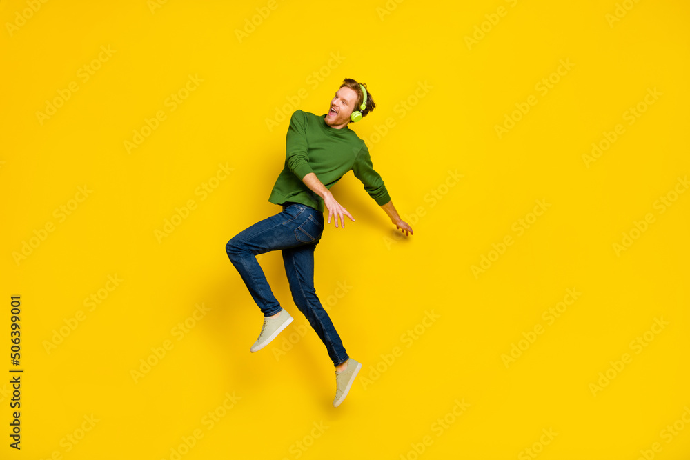 Full length photo of pretty cool man wear pullover headphones dancing empty space isolated yellow color background Full length photo of pretty cool man wear pullover headphones dancing empty space isolated yellow color background