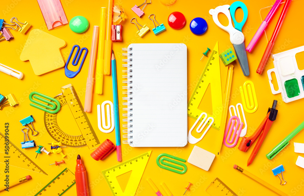 Back to school flat lay with a copy space. Empty mockup notepad and school supplies on a yellow background. Top view. Back to school flat lay with a copy space. Empty mockup notepad and school supplies on a yellow background. Top view.