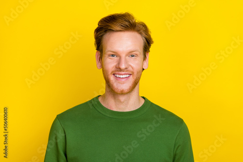 Photo of attractive charming young guy dressed green sweater smiling isolated yellow color background © deagreez