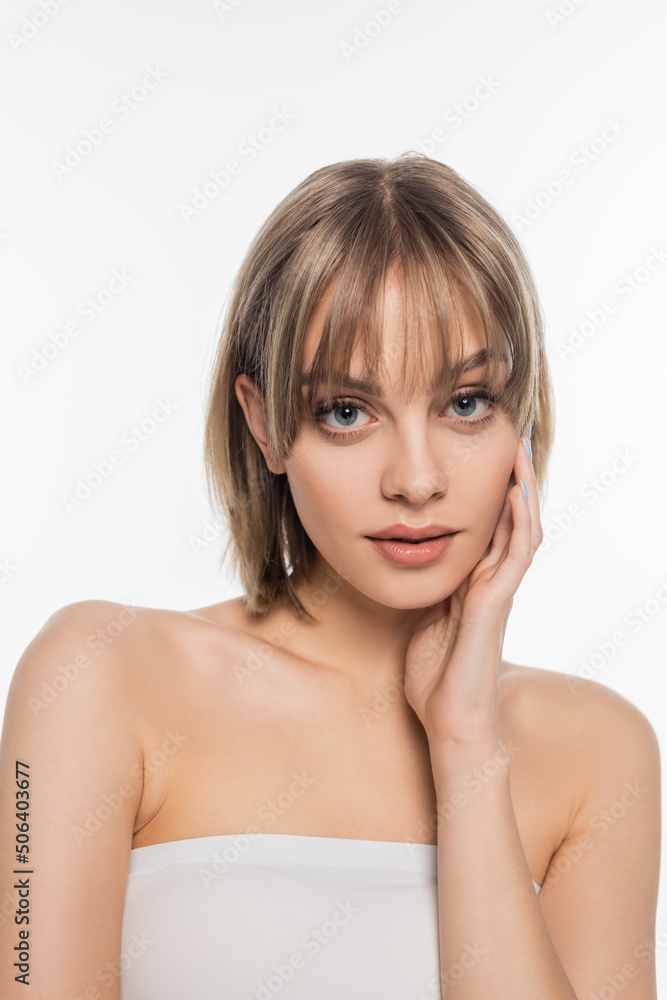 young woman with bare shoulders touching cheek isolated on white young woman with bare shoulders touching cheek isolated on white