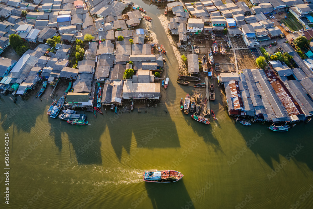 Aerial view of fishing boat speeding through fisherman village at Pak Nam Sichon, the estuary area in Chumphon province, Thailand.