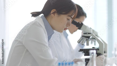 顕微鏡を覗く白衣の女性
