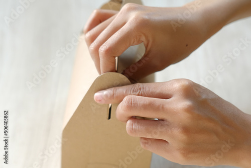 Close-up of female hand holding an ornate cardboard packaging box