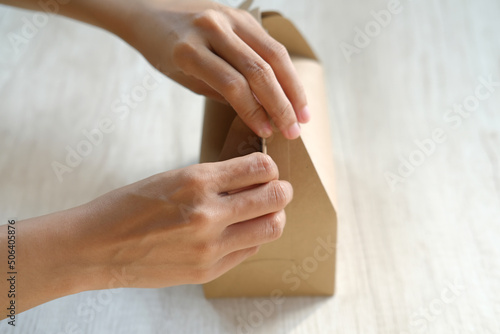 Close-up of female hand holding an ornate cardboard packaging box