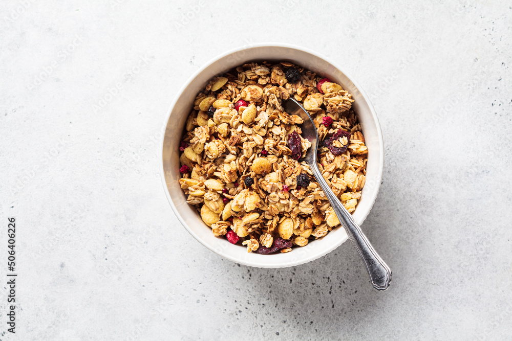 Homemade granola in white bowl, gray background, top view. Muesli bowl for healthy breakfast. Homemade granola in white bowl, gray background, top view. Muesli bowl for healthy breakfast.