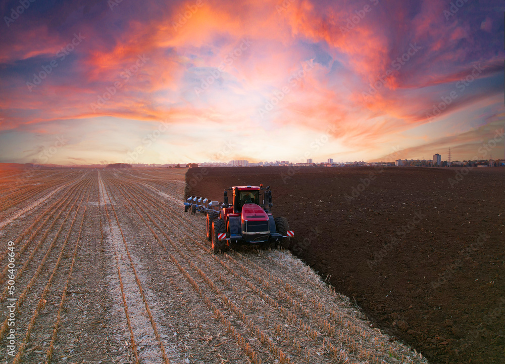Tractor Plowing field on sunset. Cultivated land and soil tillage. Tractor with disc cultivator on land cultivating. Agricultural tractor on cultivation field. Tractor disk harrow on plowing field. Tractor Plowing field on sunset. Cultivated land and soil tillage. Tractor with disc cultivator on land cultivating. Agricultural tractor on cultivation field. Tractor disk harrow on plowing field.