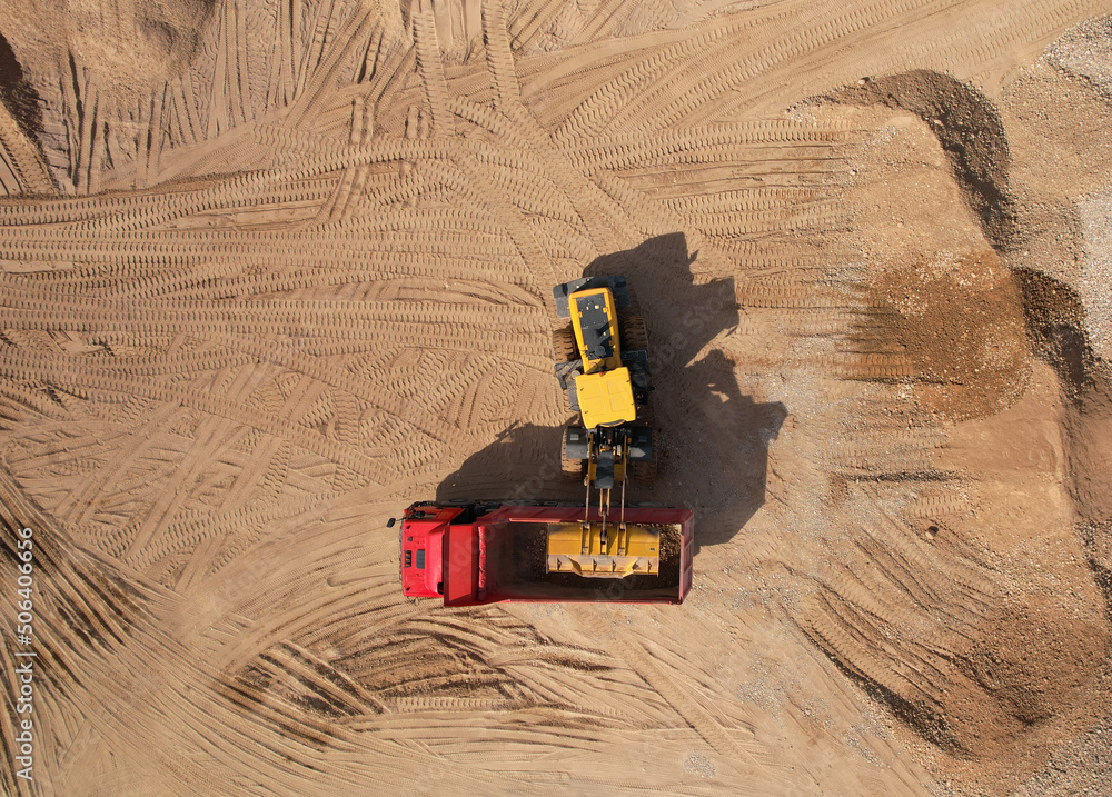 Wheel loader load sand in dump truck in open pit. Front end loader on ...