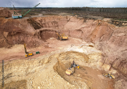 Walking dragline excavator in open pit mining. Mining clay in quarry. Opencast for the extraction limestone. Brick and Tile Industry. Heavy machinery in quarry. Excavator load ore in mining truck.