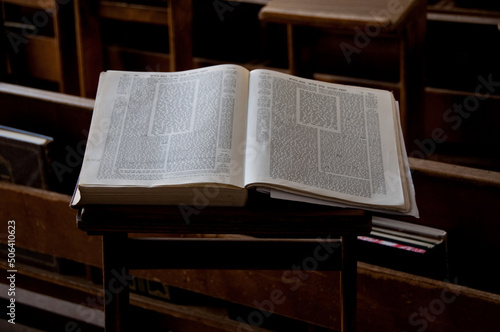 An open book of the Talmud set on a prayer stand and showing the unique page design of text and commentary in the  Jewish book of oral law. photo
