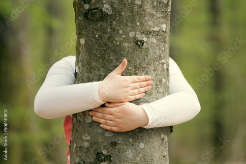 Young generation embracing nature, with a hug at a tree