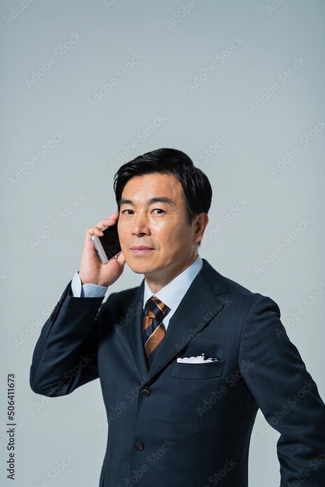 電話をする60代ビジネスマン 電話をする60代ビジネスマン