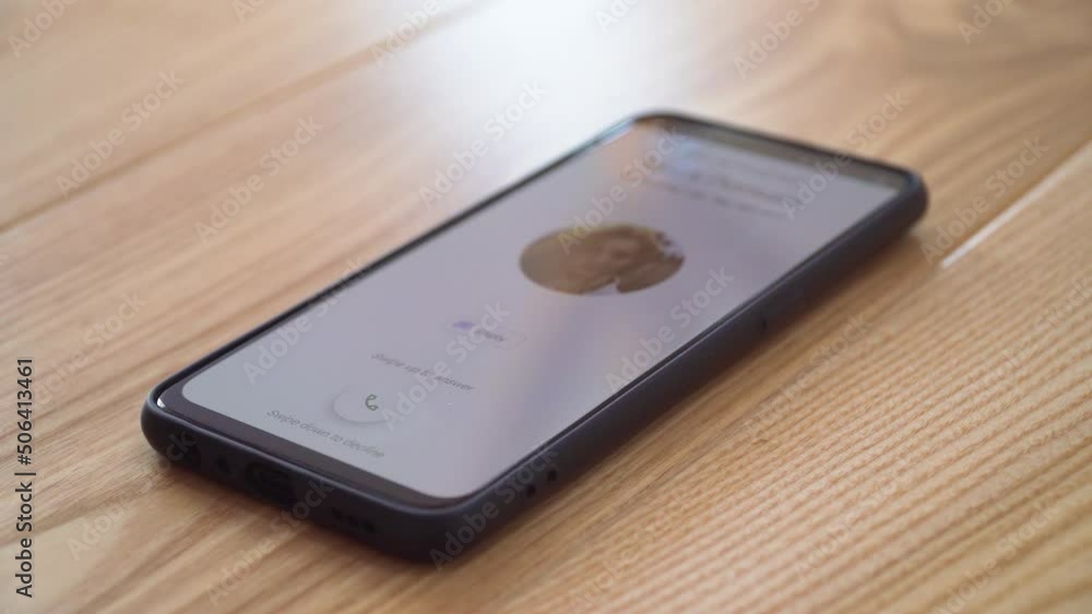 Rejecting incoming call to mobile phone lying on desk in office. Concept of digitalization and informatization