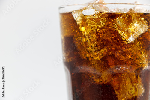 Cola glass with crushed on a white background cola ice in glass and there is water droplets around. cool black fresh drink.