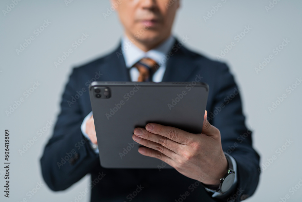 タブレット端末を操作する60代ビジネスマン