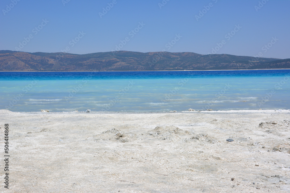 turkish mountain lake Salda with blue water and white sand in hot sunny day