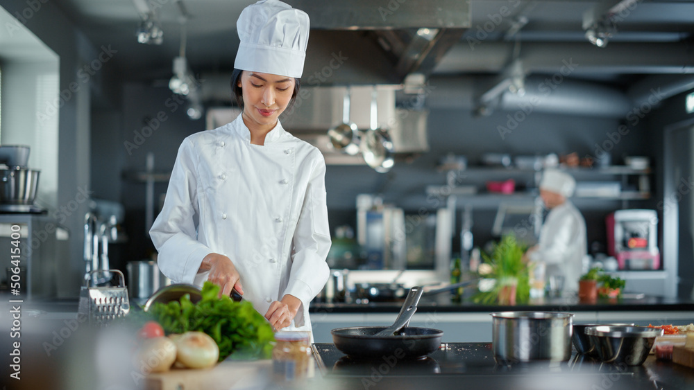Modern Kitchen Restaurant: Portrait of Asian Female Chef, Crossing Arms and Looking at Camera Smiles. Professional Cooking Delicious and Authentic Food, Cuts Vegetables, Preparing Healthy Meal Modern Kitchen Restaurant: Portrait of Asian Female Chef, Crossing Arms and Looking at Camera Smiles. Professional Cooking Delicious and Authentic Food, Cuts Vegetables, Preparing Healthy Meal