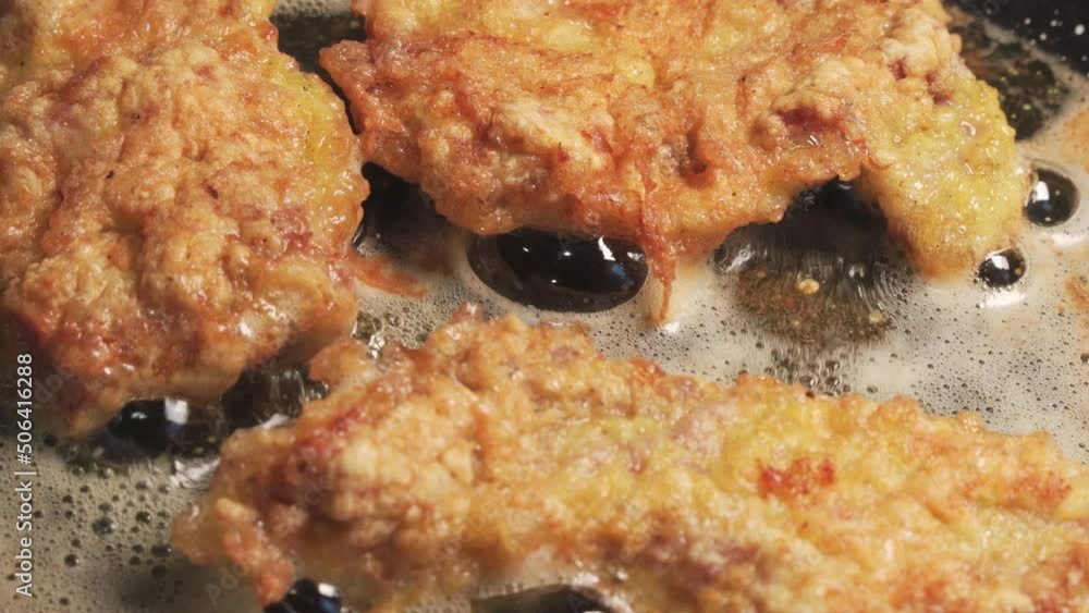 Pieces of meat are fried in a frying pan in oil. Pieces of meat are fried in a frying pan in oil.