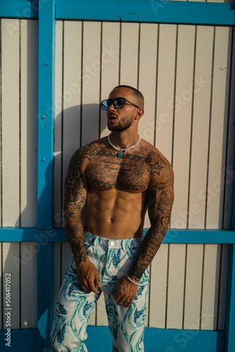 Chico joven musculoso y tatuado posando con ropa urbana en la playa © MiguelAngelJunquera