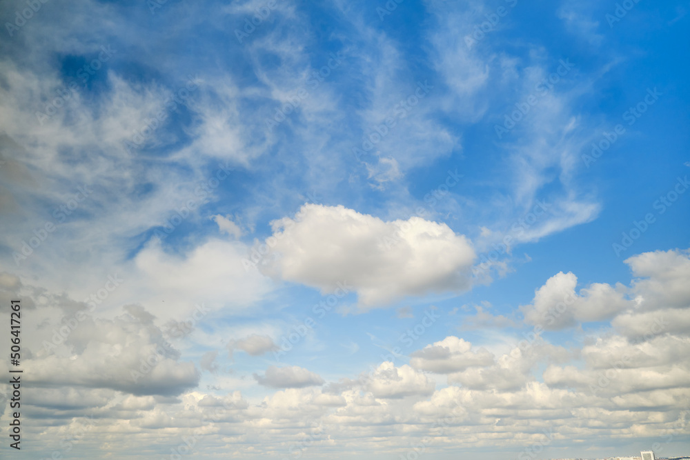 Fototapeta premium White cumulus clouds in the blue sky. Bright beautiful sky, copy space background