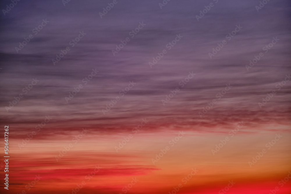 Evening red clouds in the sunset sky. Nature in colors from blue-purple to yellow-pink after sundown