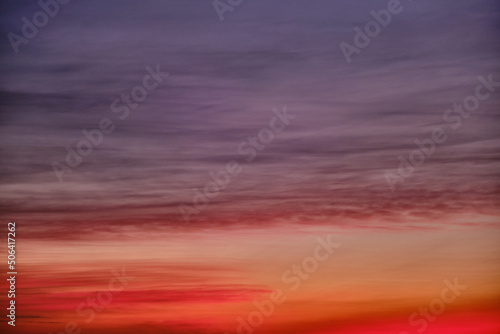 Evening red clouds in the sunset sky. Nature in colors from blue-purple to yellow-pink after sundown