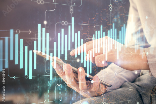 Double exposure of man's hands holding and using a digital device and forex graph drawing. Financial market concept. © peshkova