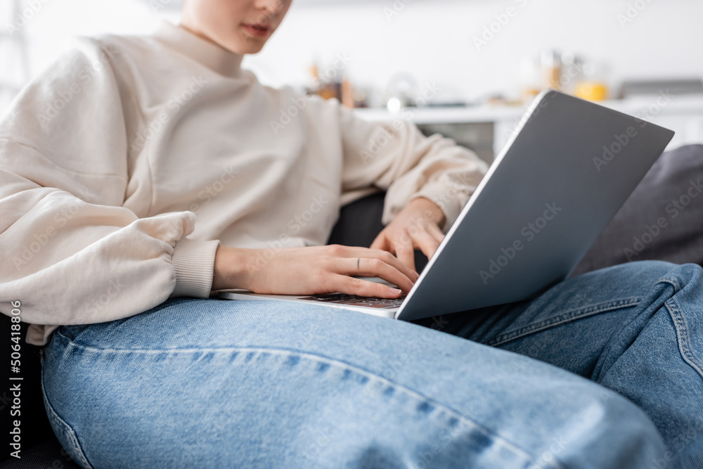 cropped view of woman typing on laptop on blurred background cropped view of woman typing on laptop on blurred background