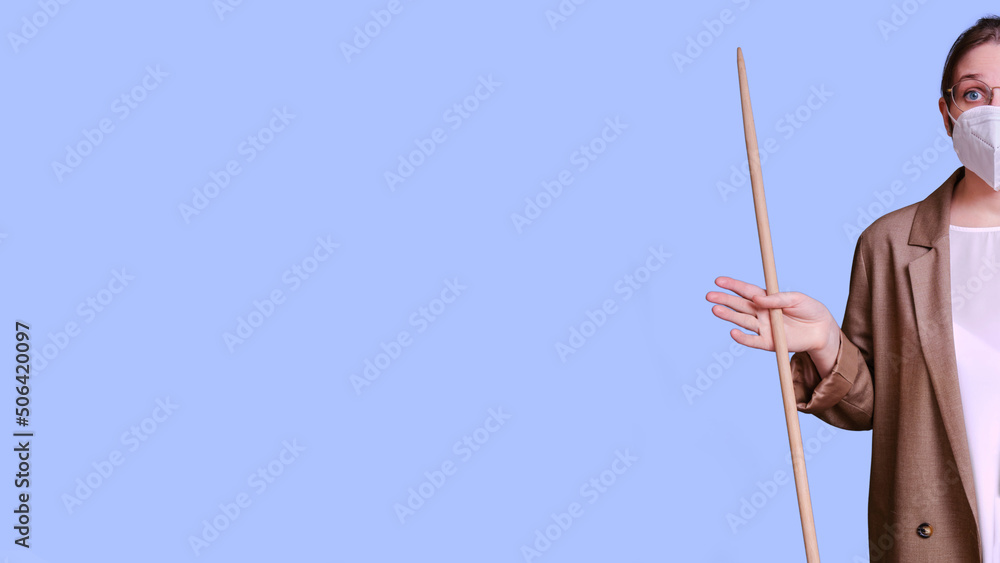 Woman teacher in a medical face mask makes a helpless gesture on a studio purple background, banner copy space Woman teacher in a medical face mask makes a helpless gesture on a studio purple background, banner copy space